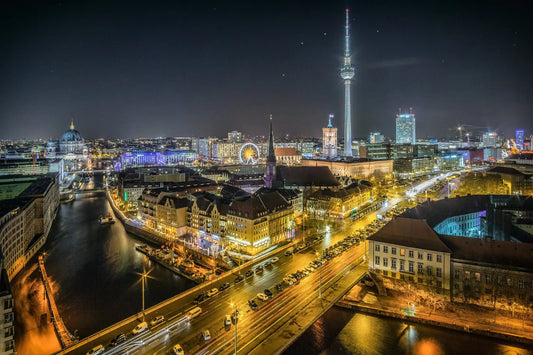 Næturútsýni yfir Berlín með lýstri sjónvarpsturninum (Fernsehturm), árbakkanum við Spree og upplýstum byggingum í miðborginni.